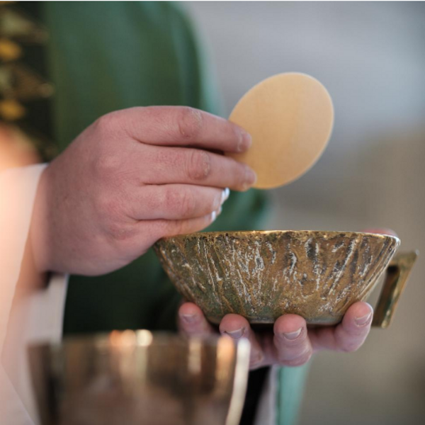 Kommunion / Markus Weinländer aus Pfarrbriefservice.de Hostie in der Hand des Priesters